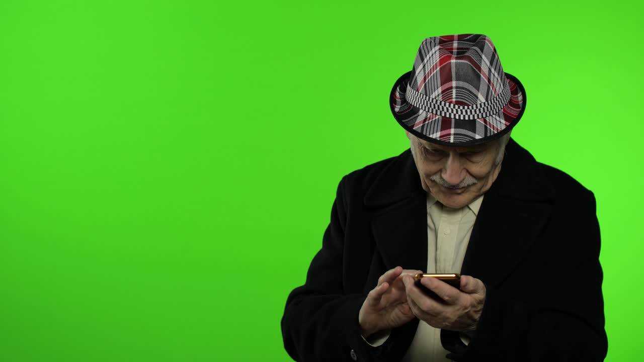 hombre de edad avanzada usando un teléfono inteligente, señalando algo con la mano