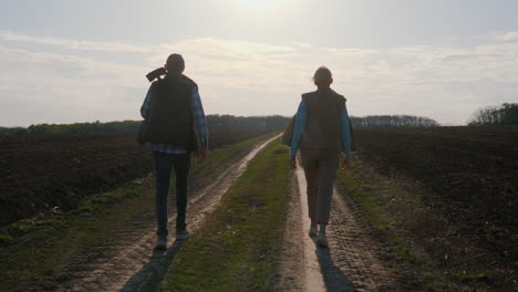 una pareja caminando por un camino de campo.