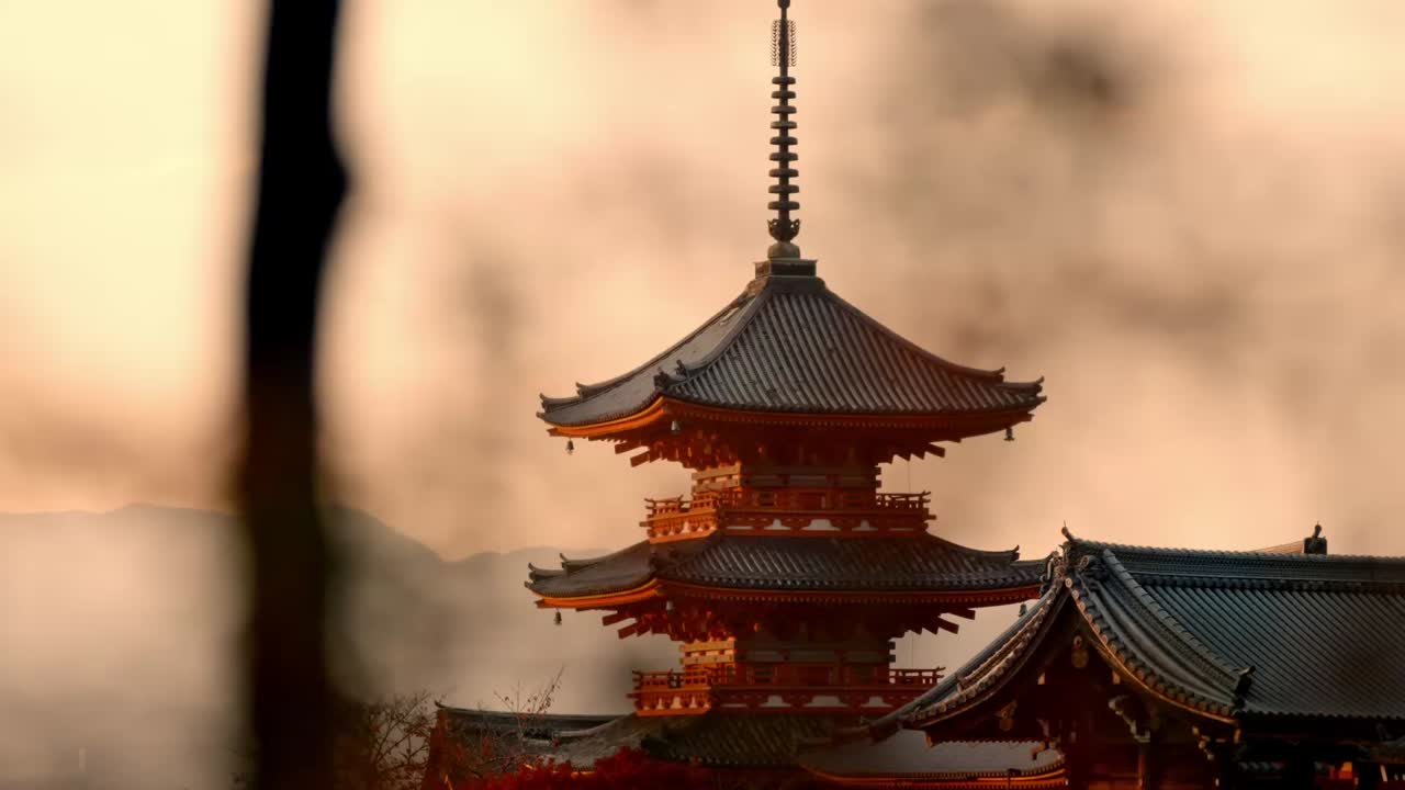 The iconic Kiyomizu-dera Temple pagoda bathed in the golden light of sunset, with vibrant red autumn foliage surrounding the scene.