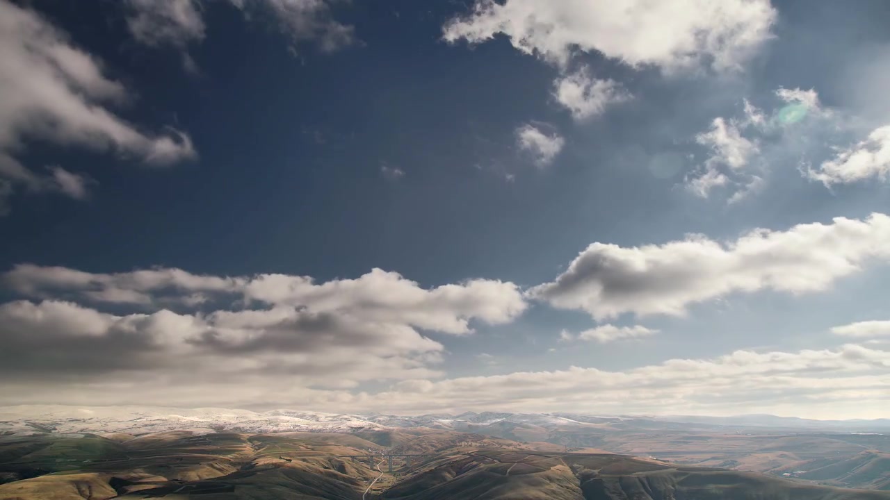 Time Lapse of Clouds Moving Over Snowy Mountain Range