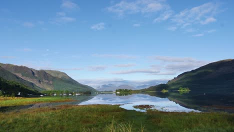 Zeitraffer-Eines-Sees-Mit-Segelbooten-Und-Wechselnden-Lichtern-Und-Blauem-Himmel-In-Schottland