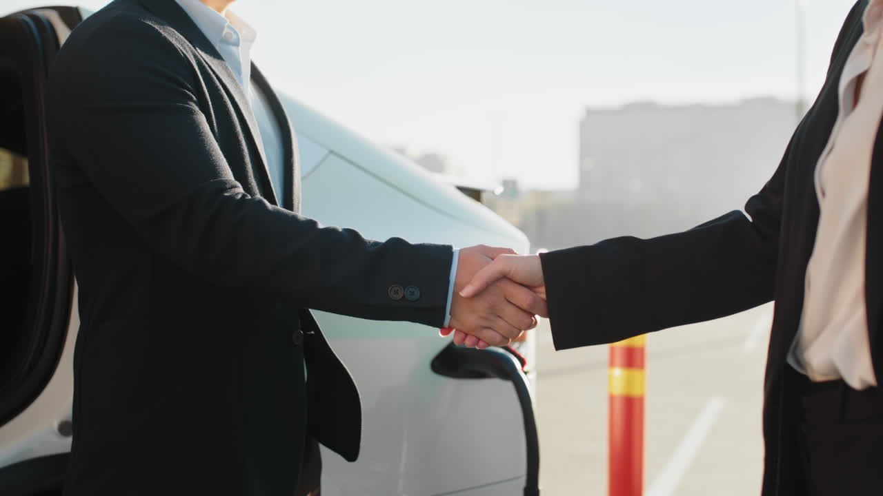 apretón de manos de negocios por coche eléctrico
