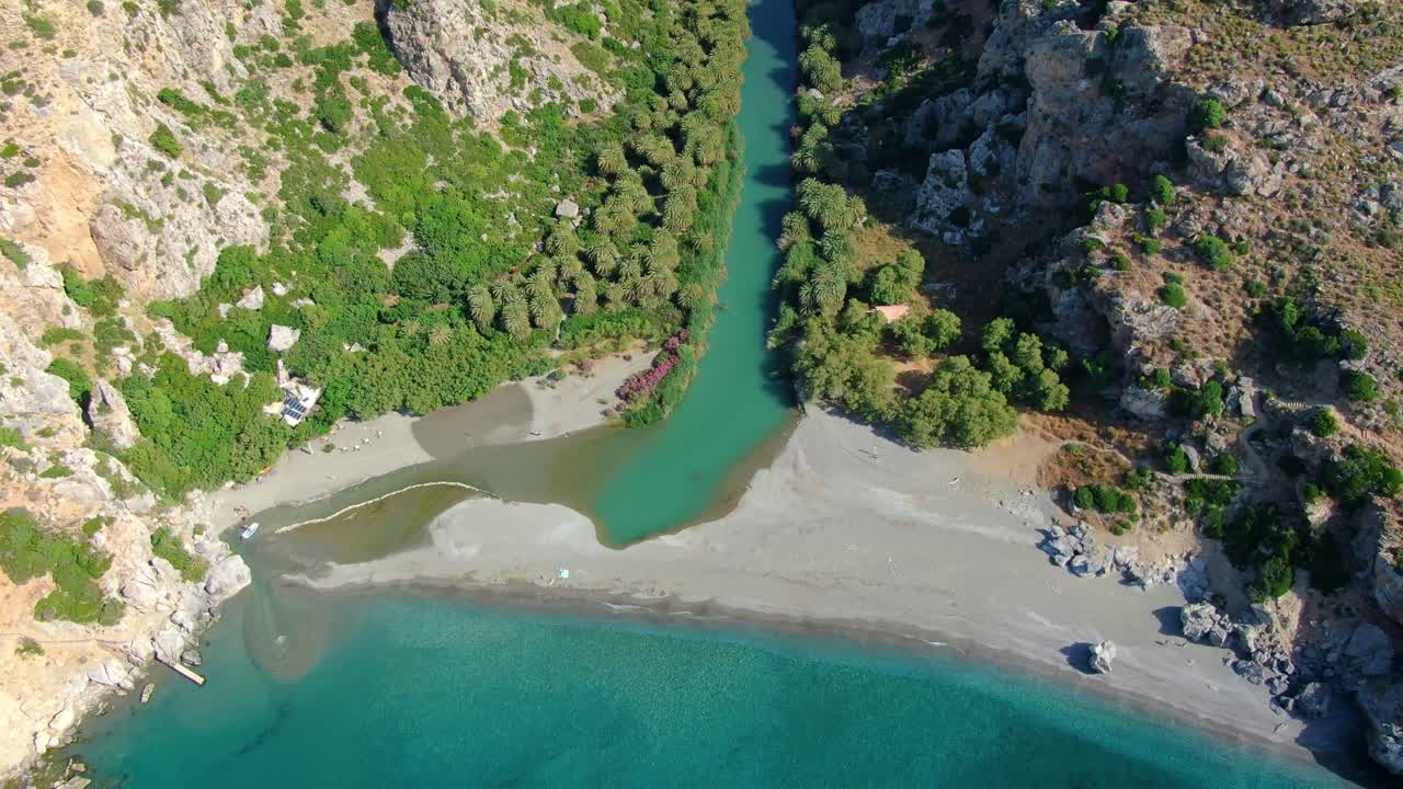 Aerial tilt revealing Kourtaliotis river coming down the mountain towards sea in Crete, Greece