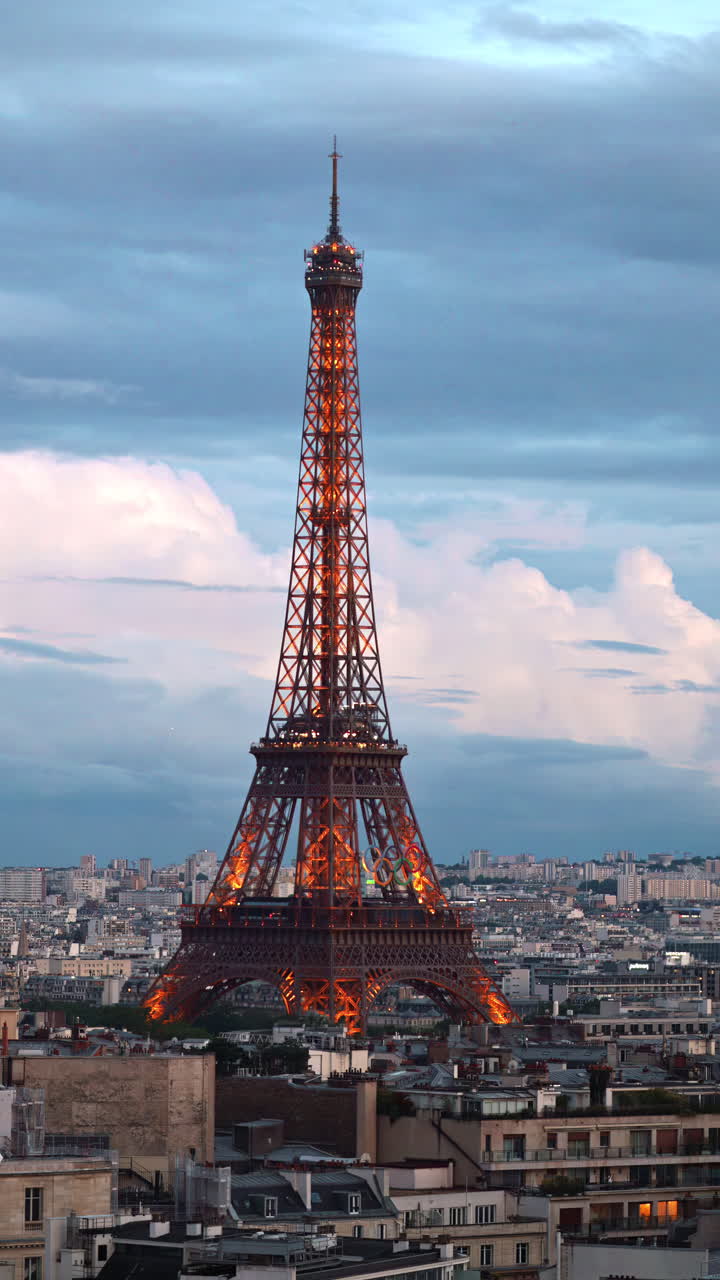 The Eiffel Tower with the Olympic Games sign sparkling in the evening in Paris, France. Vertical