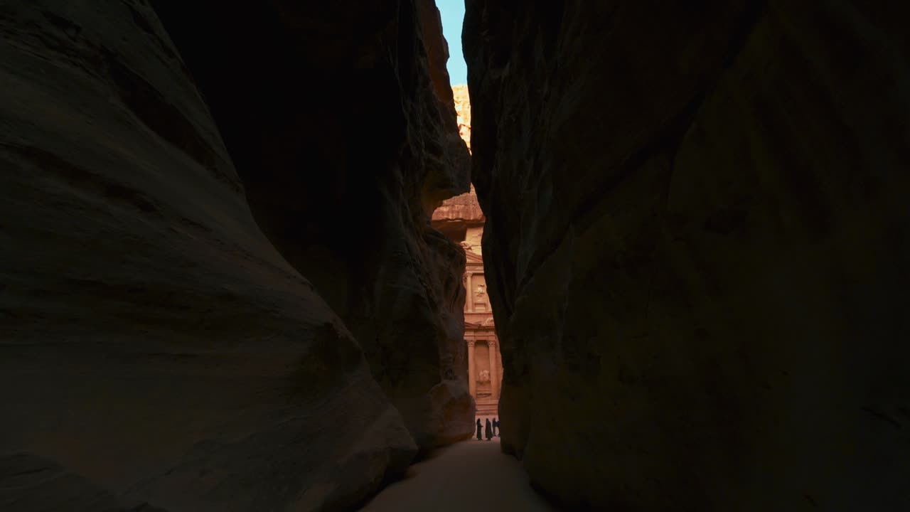 caminando hacia el tesoro a través de la siq en petra, sitio histórico del patrimonio de la unesco tallado en piedra arenisca en jordania. famoso indiana jones última cruzada lugar de filmación y destino turístico khaznet. disparo revelador.