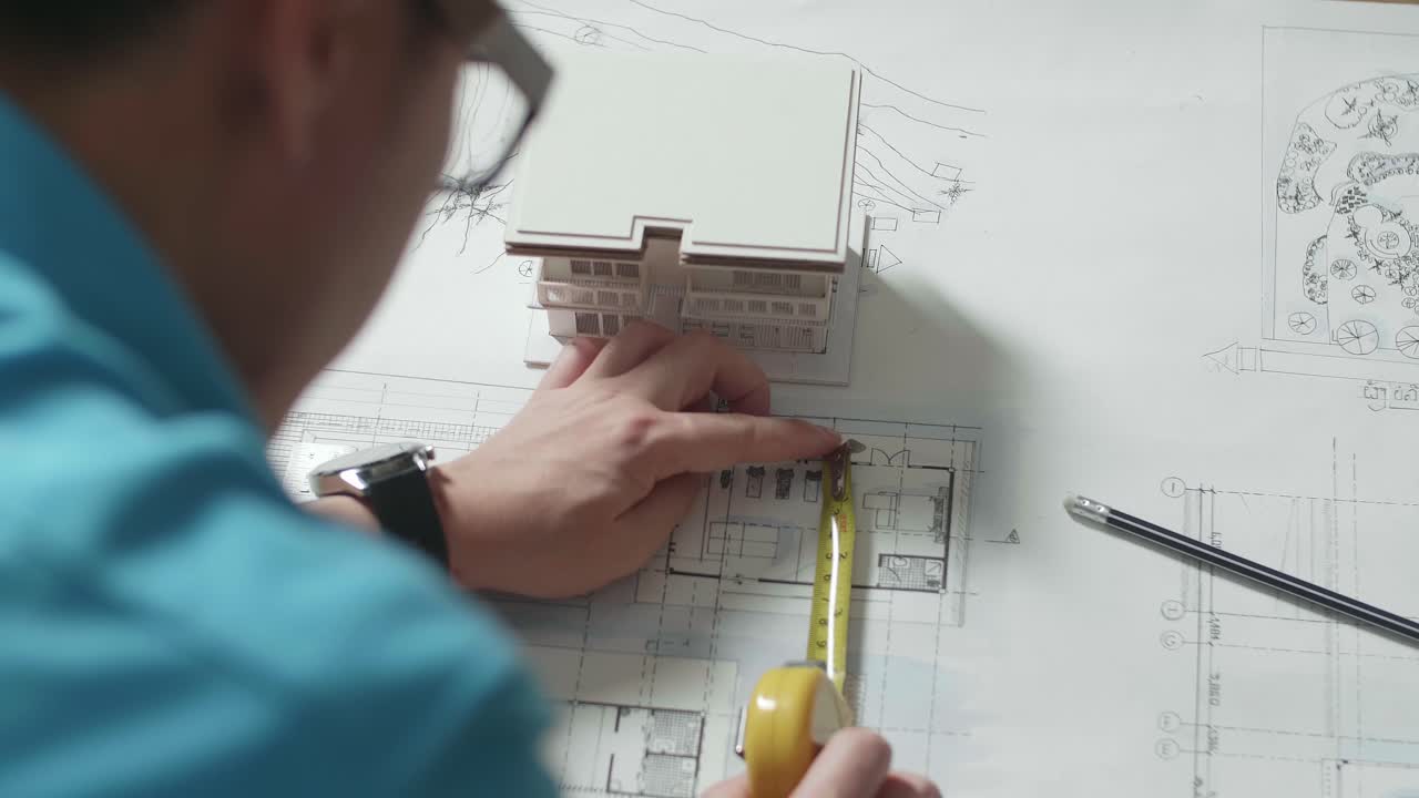 Architetto che lavora su progetti edilizi e un modellino.