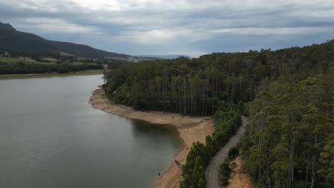 Vista-Aérea-De-Las-Laderas-Boscosas-De-Las-Montañas-A-Orillas-Del-Lago-Huntsman-En-Tasmania