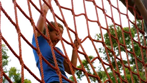 Woman-climbing-the-net-during-obstacle-course