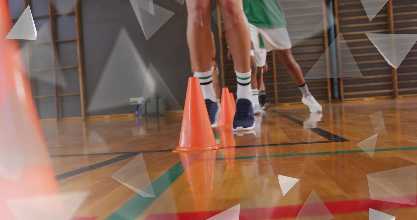 Giocatore di basket che fa un passo avanti per un esercizio di allenamento, raccoglie la palla e palleggia tra i coni