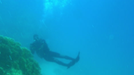 aqualunger con cámara nadando bajo el mar