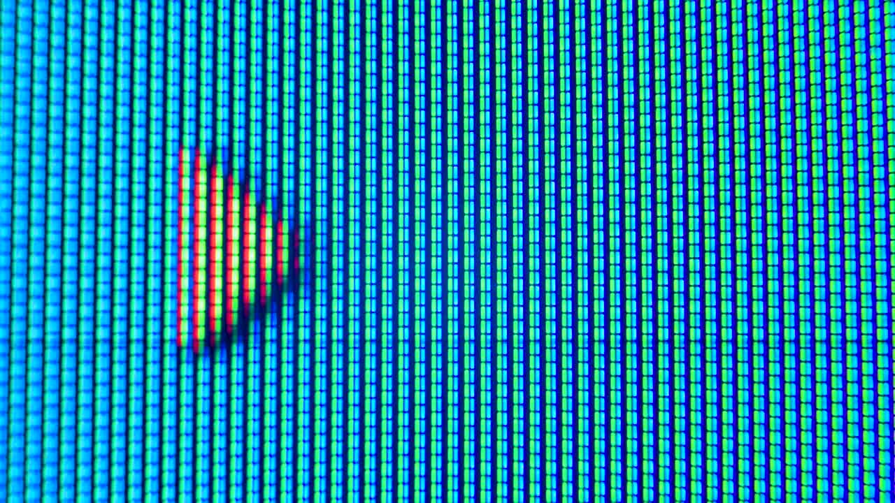 píxeles de una vieja pantalla de televisión analógica de cerca. los puntos rojos, azules y verdes crean una flecha en movimiento en la pantalla. macro. de cerca