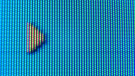 pixels of an old analog tv screen close up. red, blue and green dots create a moving arrow on the display. macro. close up