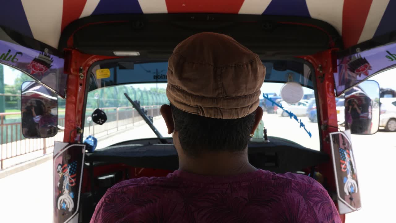 Riding in the back of a Sri Lankan Tuk Tuk while driver wears a face mask during covid pandemic in Colombo, Sri Lanka.