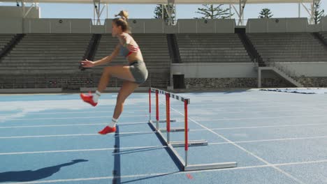 atleta caucásico haciendo obstáculos en el estadio