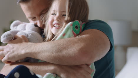 padre feliz abrazando a su hija en la cama niña pequeña riendo disfrutando del abrazo de papá padre amoroso abrazando al niño divirtiéndose fin de semana por la mañana en casa