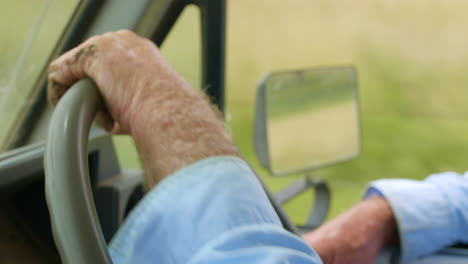 cerrar las manos insensibles de granjero en el volante de conducción en la carretera rural australiana, 4k
