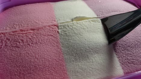 helado a rayas con tema de barbie con sabor a fresa, vainilla y corriente negra en tina rosa, delicioso postre dominical servido con una cuchara de acero inoxidable