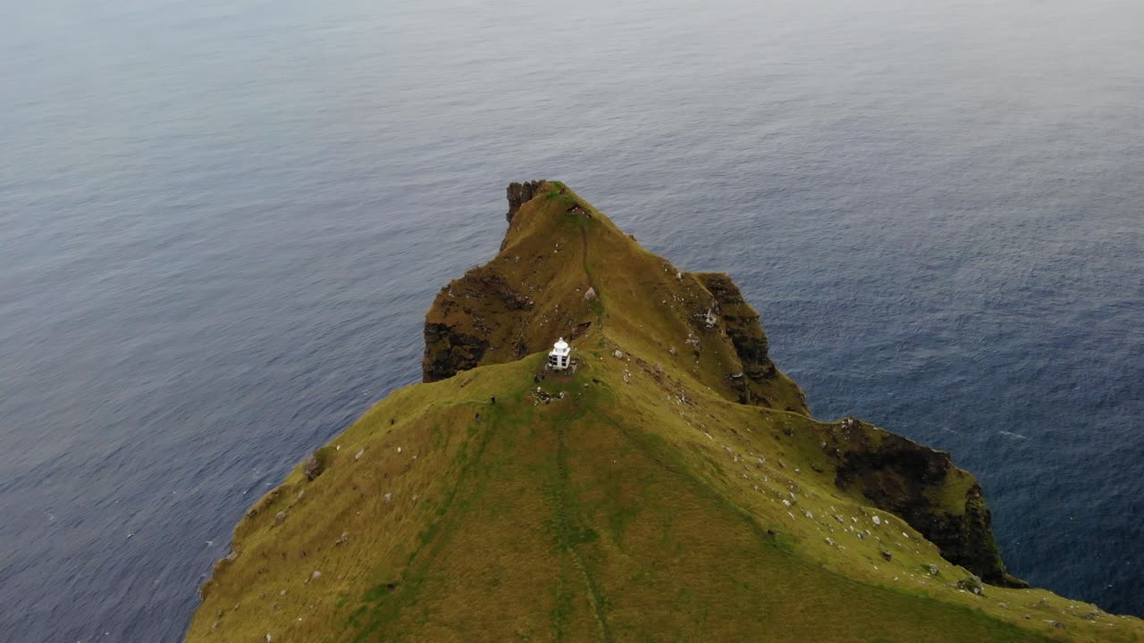 hermosa vista aérea sobre el océano del pequeño faro kalsoy entre los grandes acantilados de la isla de kallur en las islas feroe