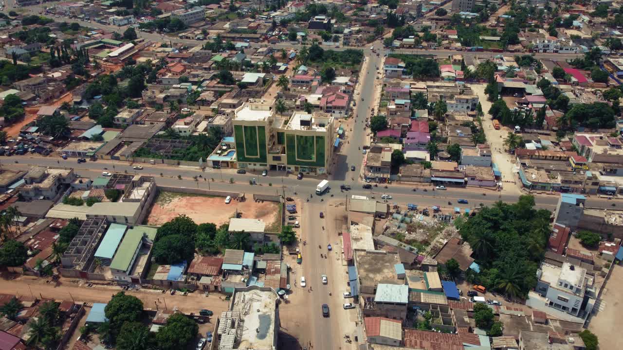 vista aérea cinematográfica ascendente del tráfico de la ciudad africana, que muestra el edificio de las torres gemelas, lomé, áfrica occidental