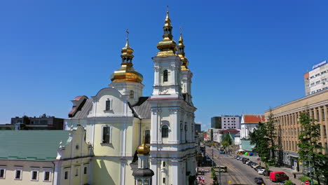 beautiful christian cathedral with golden cupolas shining in the bright sun. lively city in summer. clear blue skies above the church.