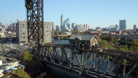 fixed aerial view of train crossing bridge in chicago, skyline in background