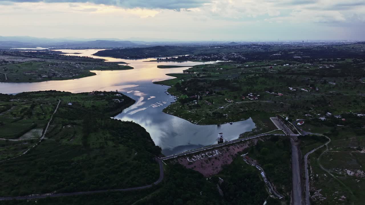 Bird's eye panoramic overview of Valsequillo Puebla Mexico dam, clear water reflecting cloudy blue hour sky
