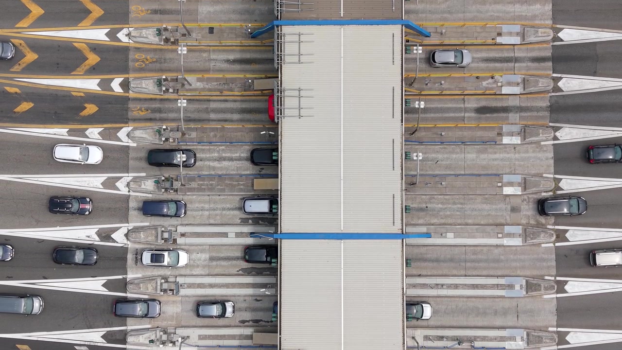Luchtperspectief van voertuigen die door meerdere tolpoorten rijden bij Milano Sud, wat nuttige beelden oplevert voor verhalen over transport, logistiek, infrastructuur en stedelijke mobiliteit