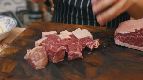 primer plano de cortar la carne en una tabla cortada de madera con un cuchillo de cocina