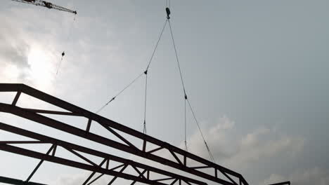 cranes lifting steel beams at a construction site