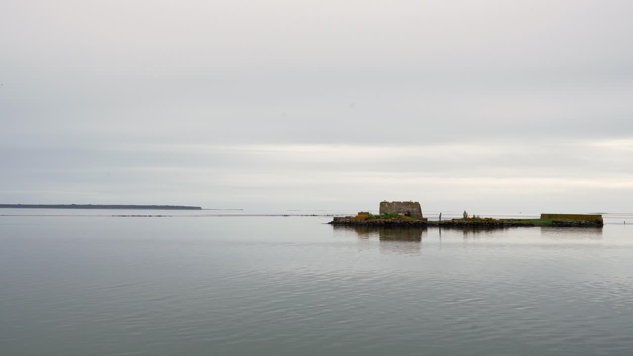 Stille hav, grå dag, overskyet ved Wexford Havneindsejling, Irland.