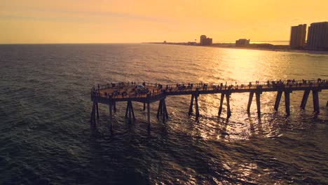 A-dramatic-orbit-around-the-longest-pier-in-Florida-as-it-stretches-from-the-sand-into-the-ocean-with-dramatic-golden-lighting