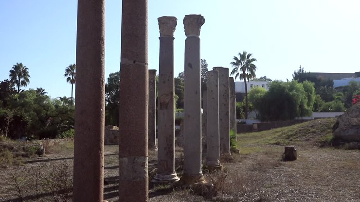 Colunas romanas antigas em Cartago, Tunísia, sob um céu azul claro.
