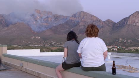 two young unrecognizable women looking at catalina mountain fire