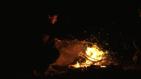 people sitting around a campfire at night