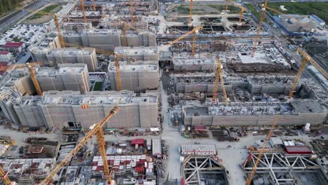 drone fly above huge construction site with yellow crane and truck working on urban development in modern smart city