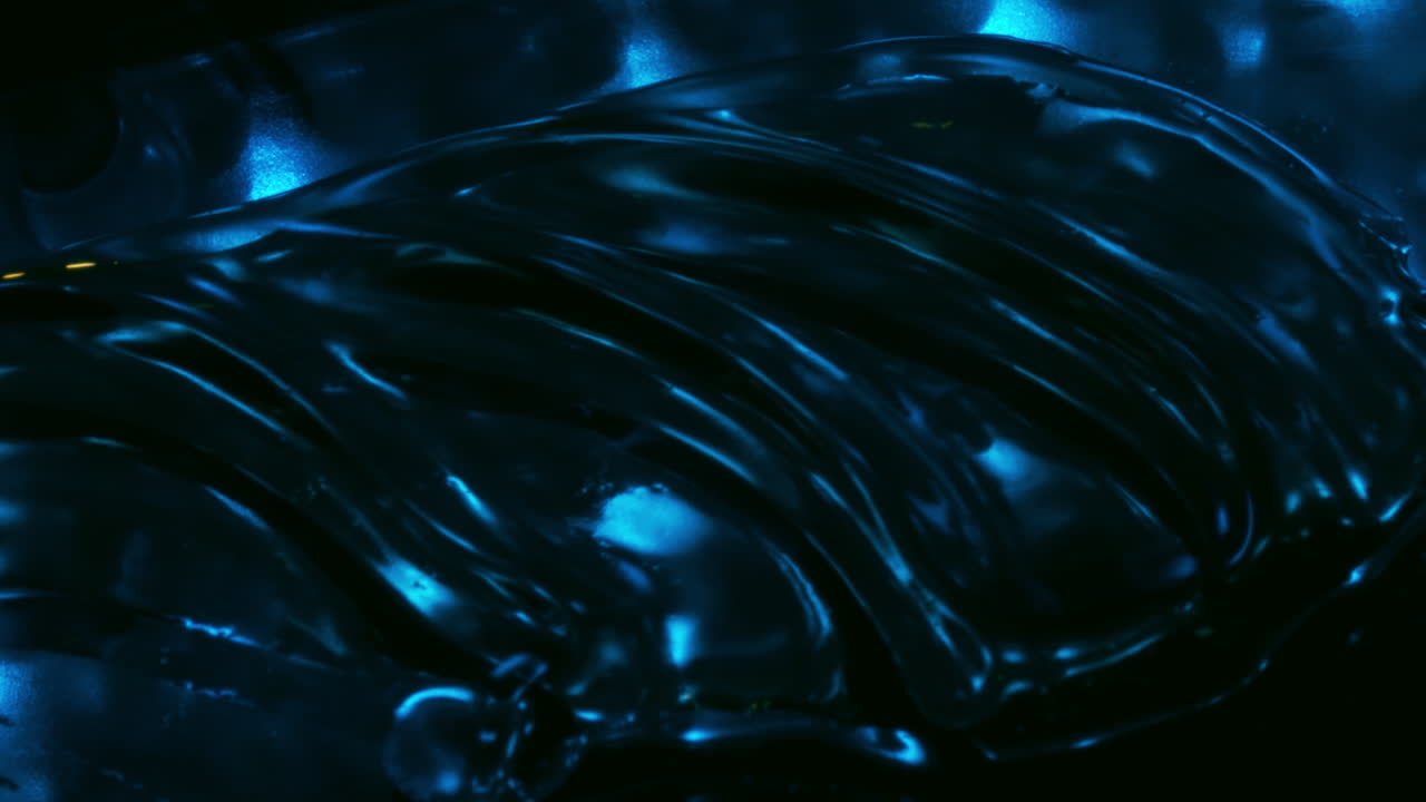 Oil with waves on surface, blowing air, extreme closeup abstract view