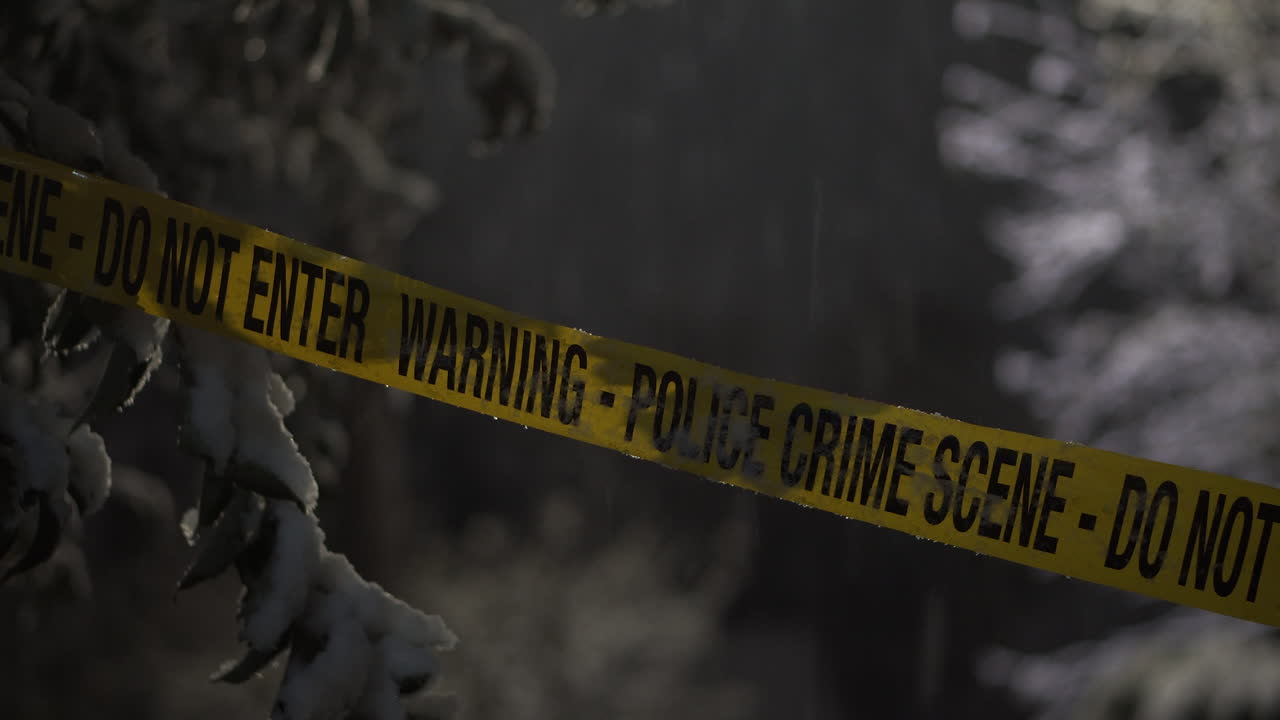 Crime Scene Police Tape Ribbon on Snowy Winter Night, Close Up