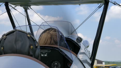 point of view of an open-cockpit bi-plane aircraft while engine starting off