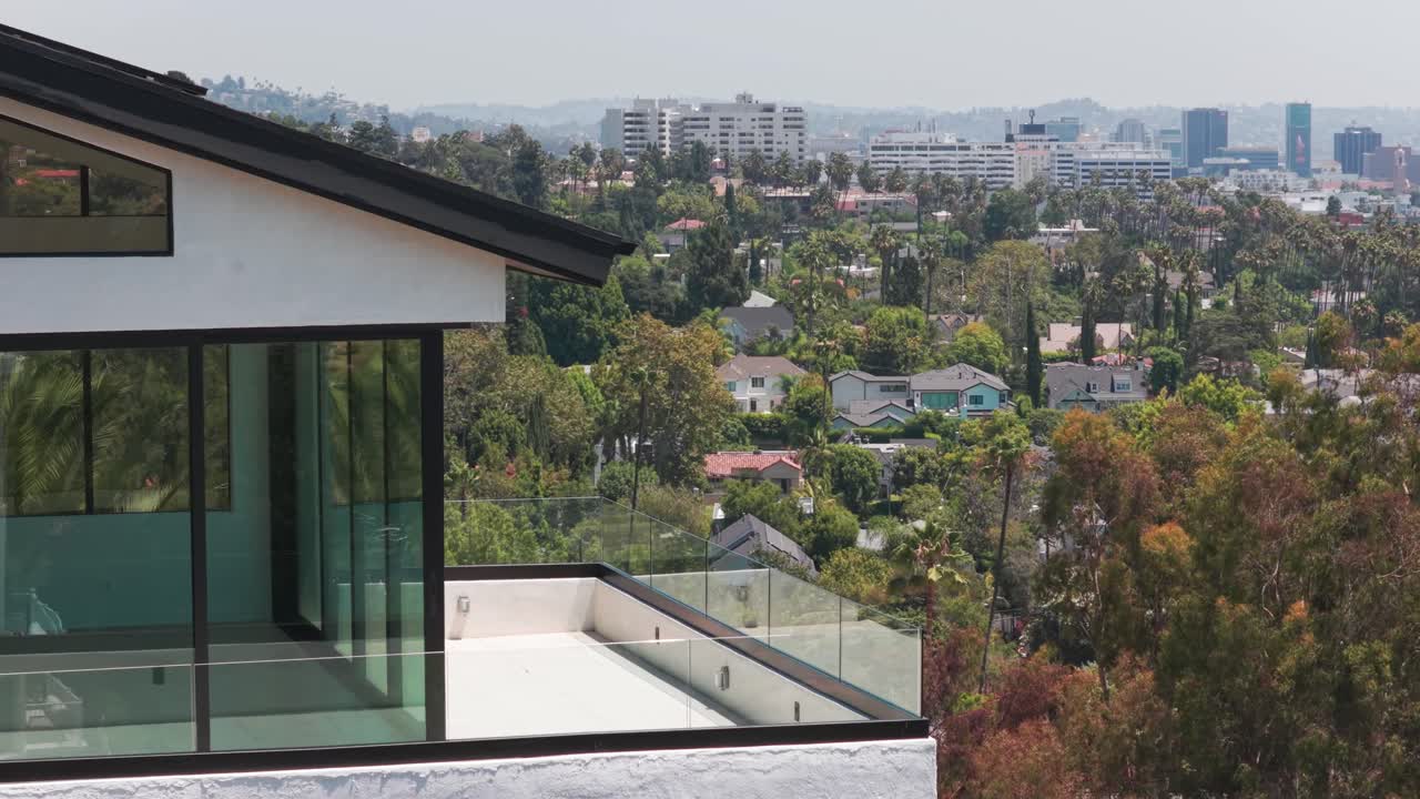 Close-up panning telephoto aerial shot of the balcony view of downtown Hollywood from an upscale home in Hollywood Hills, California. 4K