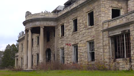 facade of an abandoned and spooky old boarding school or mansion in the countryside