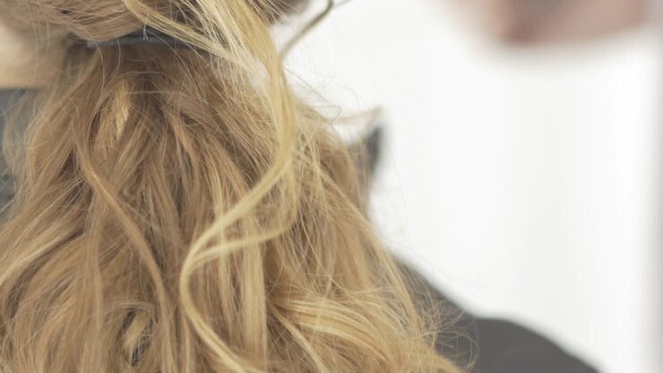 Capelli ricci femminili in salone di bellezza.