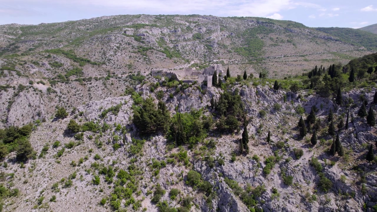 La Fortezza di Blagaj si fonde in un ampio paesaggio montuoso roccioso in Bosnia ed Erzegovina, panoramica aerea