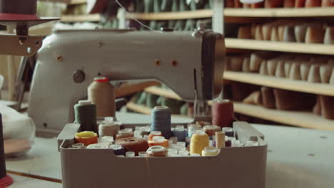 sewing machine and spools of thread in workshop