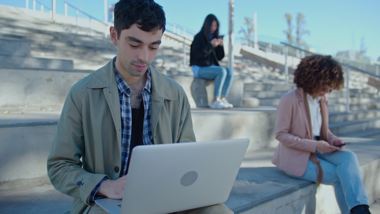 Young Businessman Working on Laptop Outdoors in the City