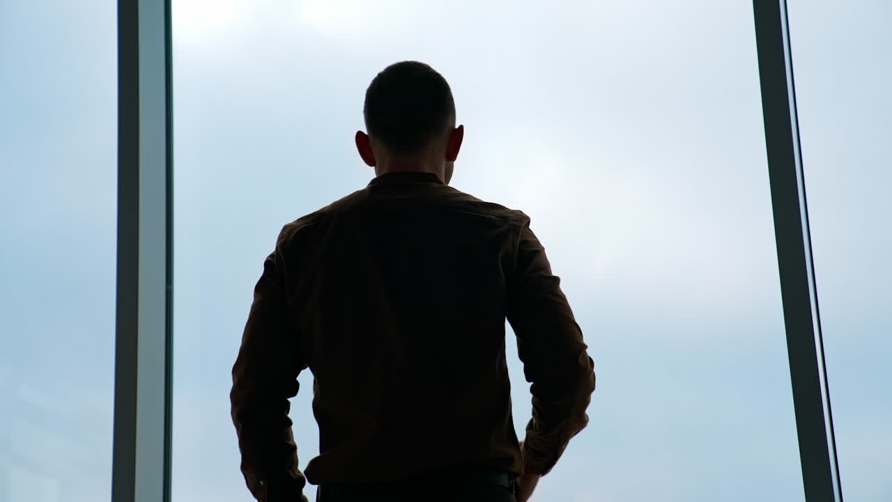 Businessman standing in his office. Business District Panoramic Window View