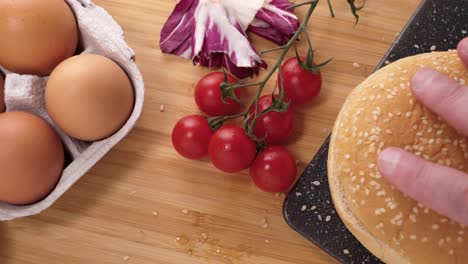 Placing-bread-and-preparing-to-cook-a-gourmet-fresh-tasty-hamburger-at-home-medium-shot