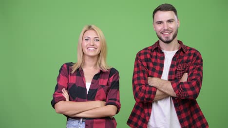 young happy couple showing something together