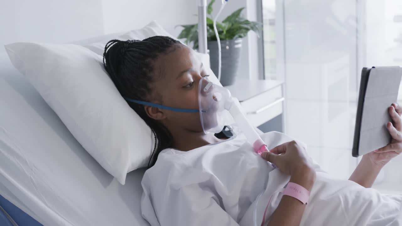paciente afroamericana con máscara de oxígeno y tableta en la habitación del hospital, cámara lenta