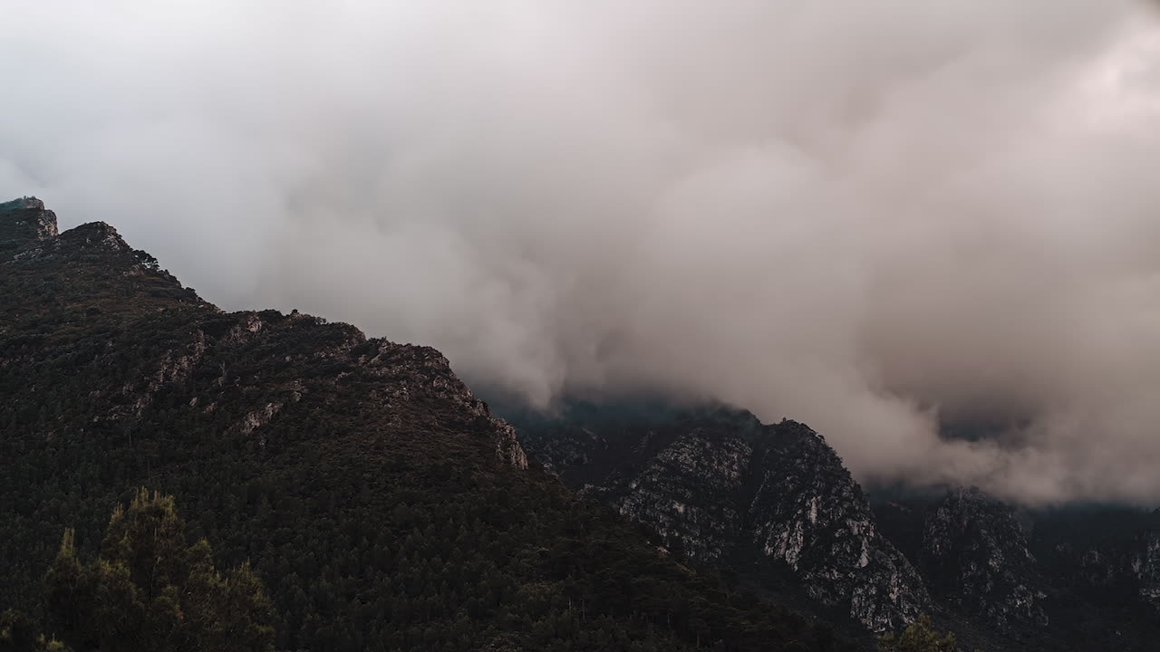 Hyperlapse of clouds swirling dramatically around majestic mountain peaks