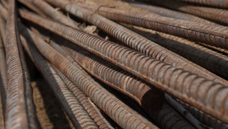 stack of rusty metal reinforcement rods laying on ground